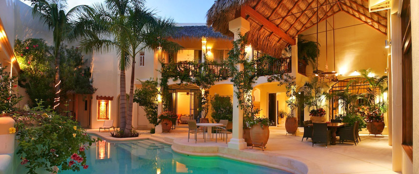 Villa exterior courtyard and pool at night.
